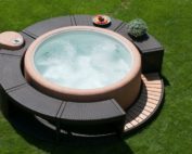 Umrandung in Polyrattan und Holz, brauner Whirlpool und Motor.