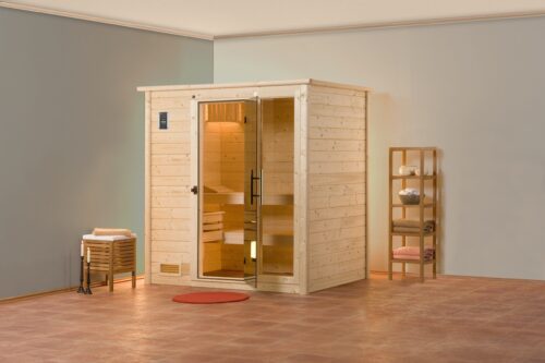 The Bergen sauna stands in a bright room in a corner. Sauna has an all-glass door and an all-glass window. It has a corner entry and stands next to two shelves.