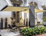 Ein grauer Unosider Gate Shade Pavillon mit beiden Dächern ausgefahren. Indirekte Beleuchtung erhellt den Gartensitzplatz.