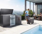Das Biohort Highboard steht auf einer grossen Terrace vor einem pool. Neben dem Highboard steht ein Mann an einem Grill und eine Familie sitzt an einem Tisch.