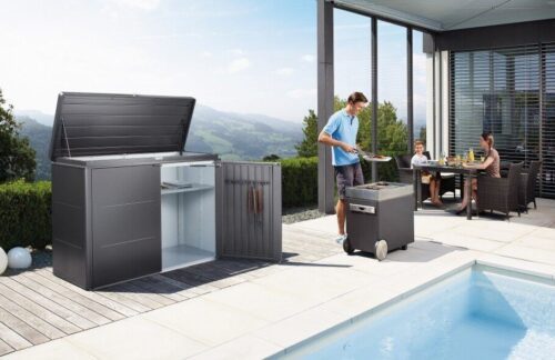 The biohort Highboard stands on a big terrace infront of a big pool. Next to the Highboard is a man at a grill and a family sitting at a table.