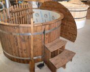 Ein dunkler Hot Pot aus Thermoholz mit Kunststoff Einsatz, Treppeneinstieg, Gitter und Umrührkehle