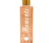 Eine rosa, orangene Flasche mit einem goldenen Deckel und mit weisser Aufschrift die sich Moments schreibt.