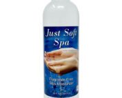 Eine weisse Flasche mit einer blauen Etikette. Auf der blauen Etikette steht in weisser Schrift geschrieben Just Soft Spa. Zwei Hände sind zu sehen.