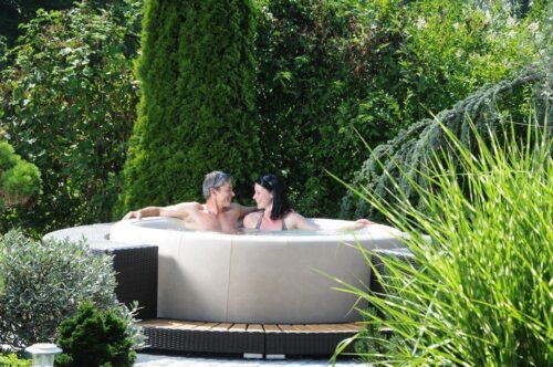 Couple sitting in a Softub Whirlpool in the garden, enjoying the warm water and the view into the garden