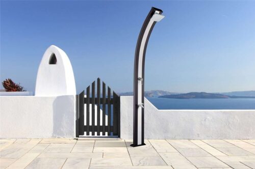 Formidra solar shower spring. A black shower next to a black gate on a terrace of a house in front of the big sea.