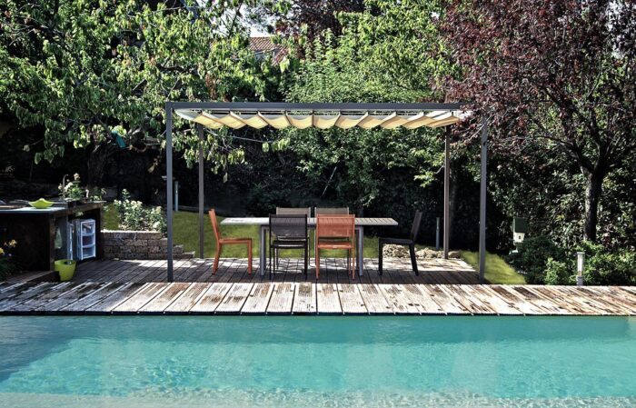 Unosider Pavillon Mood mit weissen, zusammengebundenen Vorhängen auf einer Terrasse mit Holzboden in einem Garten