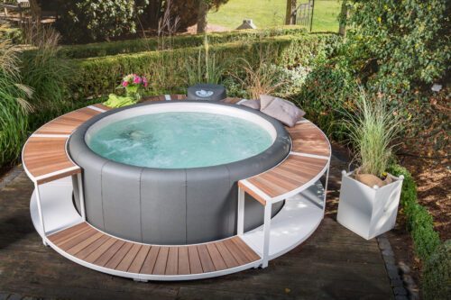 The full frame Stausee in the color creme on a terrace in a garden and a integrated Softub whirlpool.