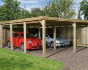 Ein Doppelcarport mit vier Balken auf jeder Seite. Links steht ein kleiner roter Alpha Romeo und rechts ein silbernes Auto.