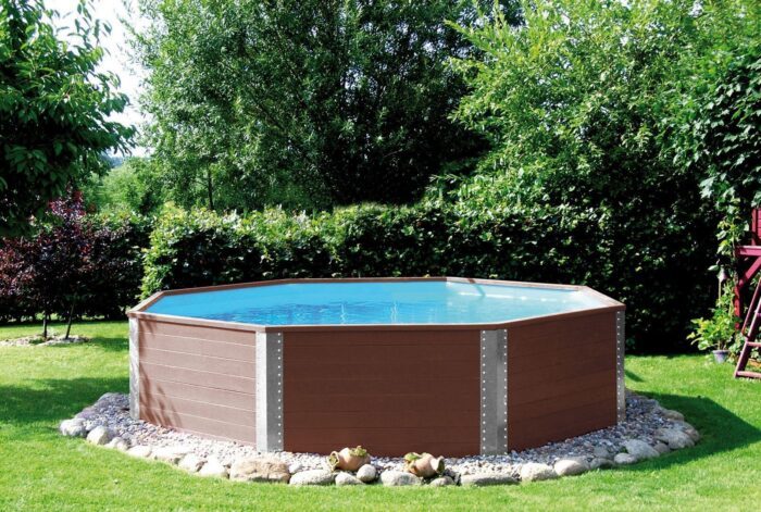 Ein dunkelbrauner, gefüllter Pool in einem Garten auf einem Steinboden. Weka Qualitäts Massivholzpool 