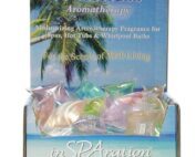 Hydro Therapies Wellness. Eine blaue Schachtel die kleine pastellfarbige Päckchen enthaltet. Auf der Schachtel ist eine Palme abgebildet.