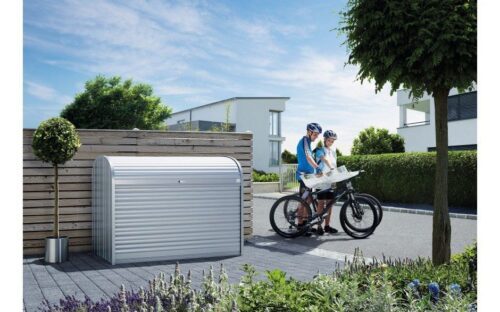 biohort Storemax standing on a wall. Nex to the box stand two people with their bicycles. biohort STOREMAX® maximum storage space in a small space and with a functional design. Ideal for storing bicycles, garden tools or waste bins.