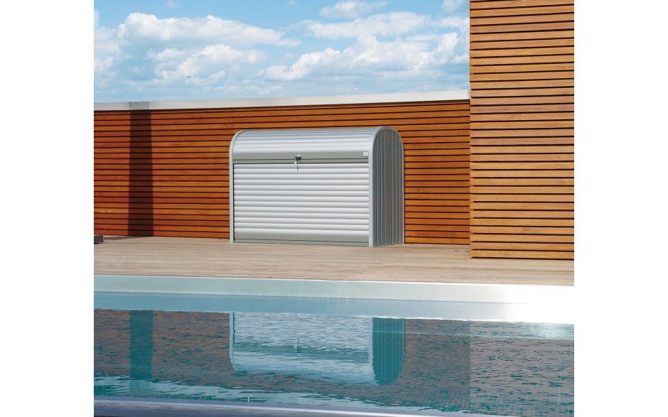 Silberne Gartenbox mit abgerundeten Ecken steht auf einer Terrasse vor einem Pool.