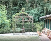 Unosider Pavillon Calicanto bedeckt mit Pflanzen in einem grünen Garten.