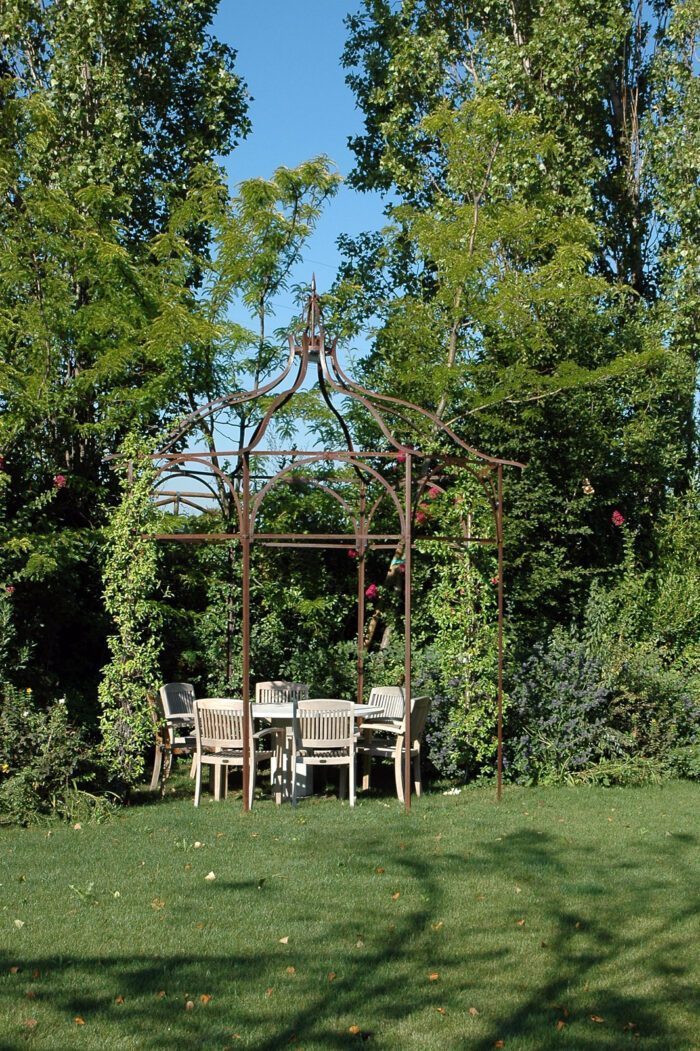 Unosider Pavillon Calicanto bedeckt mit Pflanzen in einem grünen Garten.