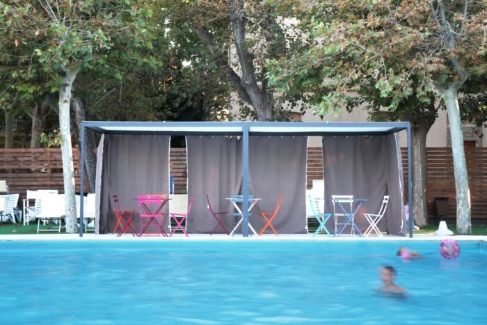 Zwei Unosider Pavillon Resort mit grauen hinten geschlossenen Vorhängen vor einem grossen Pool