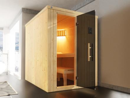The Weka Kaarina Niche Sauna. A Niche Sauna in a bright room. All-glass door with a front entry. A light is switched on inside a sauna.